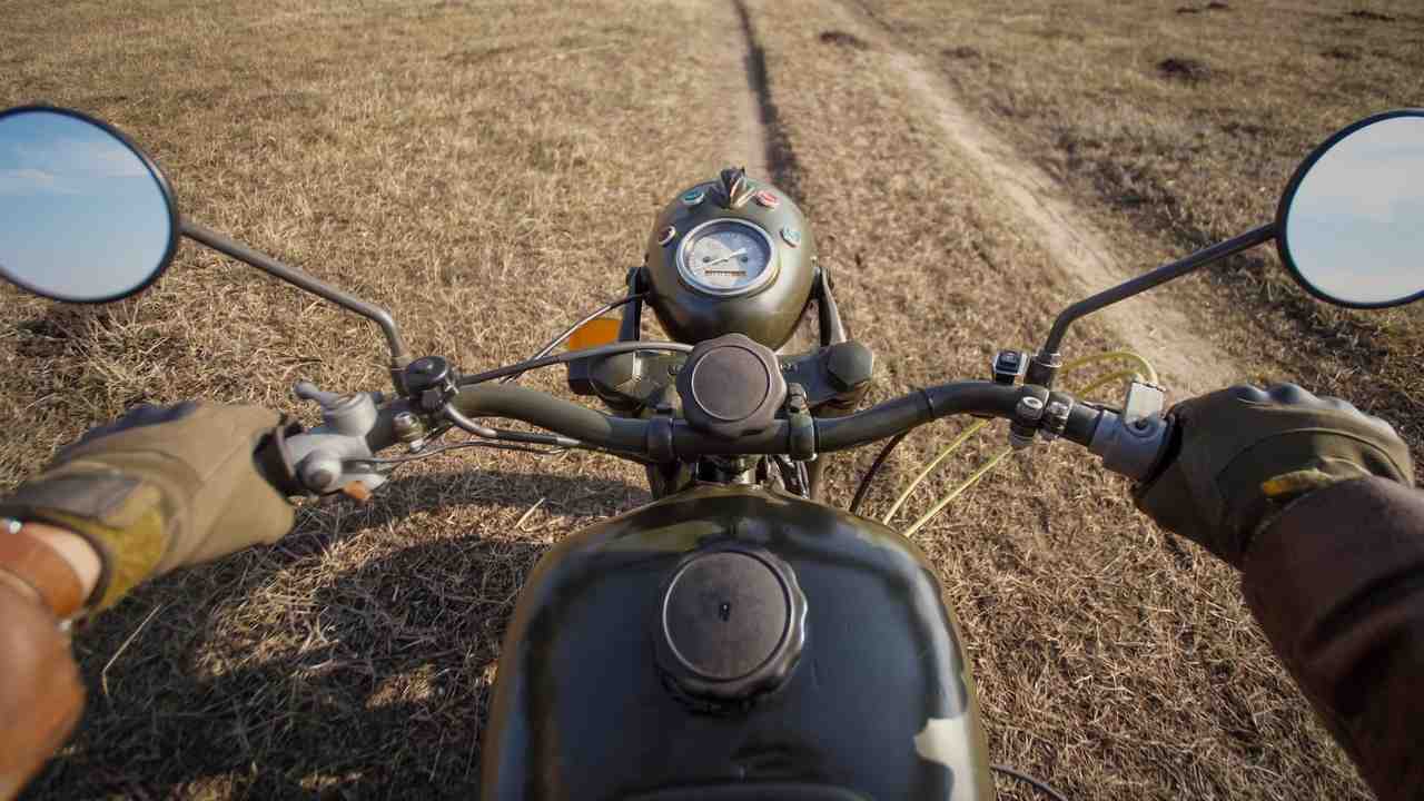 Vojenský motocykel v teréne z pohľadu jazdca počas presunu po poľnej ceste