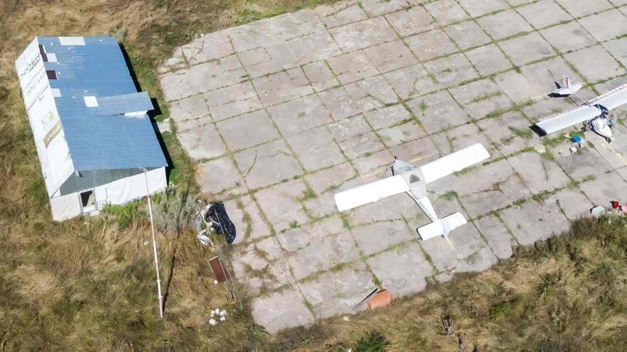 Letecký pohľad na opustený areál s budovami a pristávacou plochou v poľnej oblasti (ilustračná fotografia)